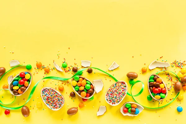 Шоколадные Пасхальные Яйца Красочные Конфеты Фоне Желтой Бумаги Плоская Кладка — стоковое фото