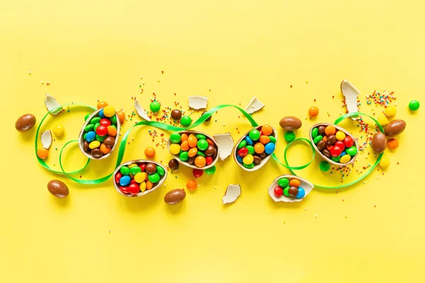 Chocolate Easter Eggs Colorful Candies Yellow Paper Background Flat Lay — Stock Photo, Image