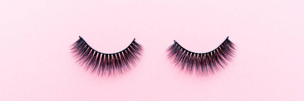 Фальшивые ресницы на розовом фоне. Концепция красоты. Косметика для грима. Вид сверху, плоский. Планировка. Место для текста и дизайна. Веб-баннер
