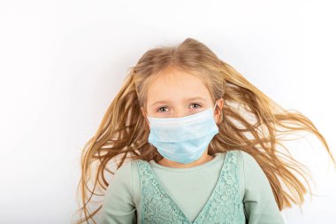 Coronavirus ve Hava kirliliği pm2.5 konsepti. Karantina sırasında korunmak için maske takan küçük Rus kız. Önleme salgını. Yurt içi kampanyada kal