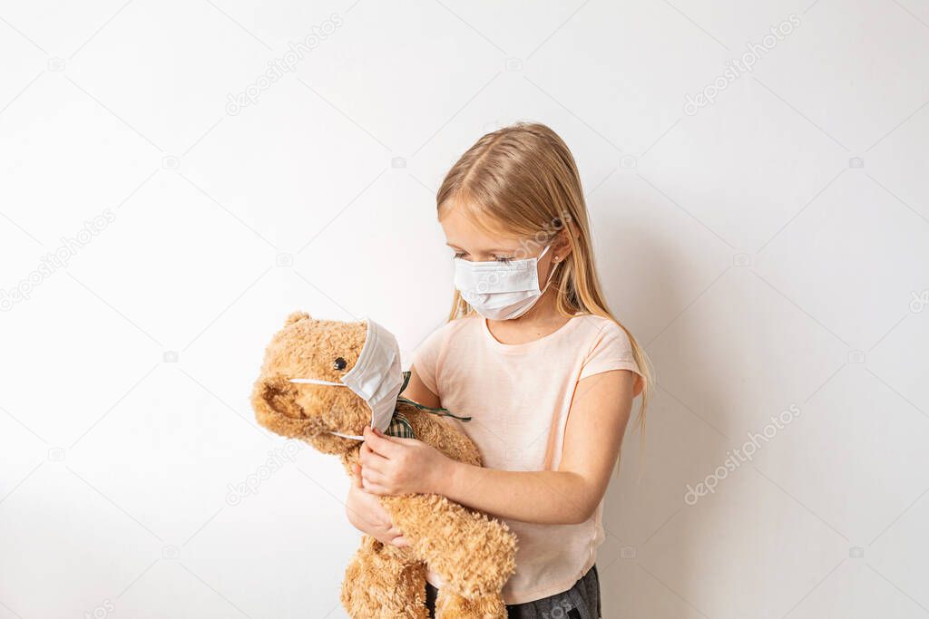 Coronavirus and Air pollution pm2.5 concept. Little russian girl wearing mask for protect and holding her teddy bear during covid-19 quarantine. Prevention epidemic. Stay at home campaign .
