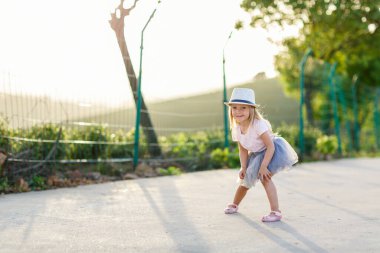 Çay tarlasının yanında uzun sarı saçlı sevimli küçük bir kızın portresi. Güzel çocuklu bir web pankartı. Mutlu gülümseyen çocuk güneşli bir yaz günü, çocukluk günü, eğitim konsepti.