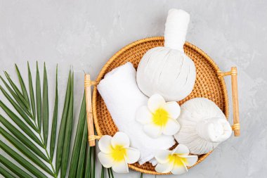 Spa masajı, vücut bakımı geçmişi. Gri taş masadaki kaplıca topları, kozmetik ürünleri, havlu ve palmiye yaprakları. Üst manzara, düz yatış, genel giderler, kopyalama alanı. Güzellik ve sağlık hizmetleri kavramı