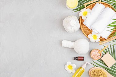 Spa masajı, vücut bakımı geçmişi. Gri taş masadaki kaplıca topları, kozmetik ürünleri, havlu ve palmiye yaprakları. Üst manzara, düz yatış, genel giderler, kopyalama alanı. Güzellik ve sağlık hizmetleri kavramı