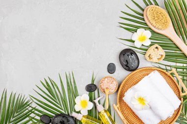Spa masajı, vücut bakımı geçmişi. Gri taş masadaki kaplıca topları, kozmetik ürünleri, havlu ve palmiye yaprakları. Üst manzara, düz yatış, genel giderler, kopyalama alanı. Güzellik ve sağlık hizmetleri kavramı