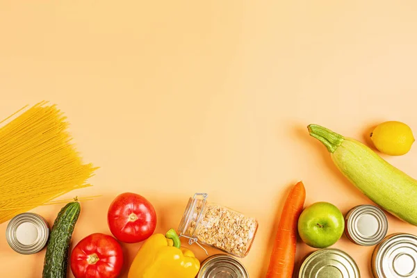 Donation bag with various food on orange background with copy space. Flat lay. top view, Mockup. Food donations or food delivery service concept. Online shopping during coronavirus covid-19 lockdown.