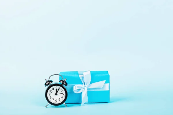 Happy Fathers Day or Birthday background. gift box, alarm clock on blue table. mockup, template, greeting card, copy space. Horizontal banner for web design.