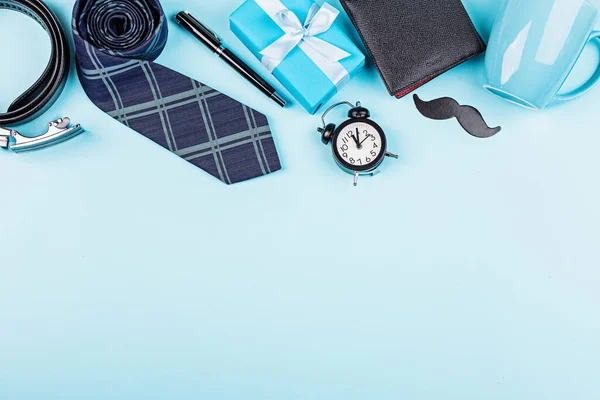 Happy Fathers Day background with wallet, gift box, coffee cup, pen, leather belt, funny moustache on table top view. Flat lay style, overhead, mockup, template, copy space.