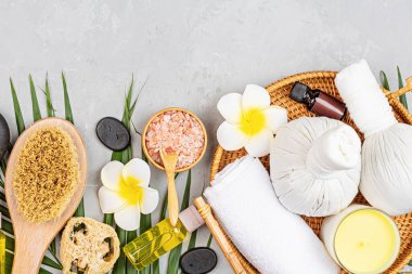 Spa masajı, vücut bakımı geçmişi. Gri taş masadaki kaplıca topları, kozmetik ürünleri, havlu ve palmiye yaprakları. Üst manzara, düz yatış, genel giderler, kopyalama alanı. Güzellik ve sağlık hizmetleri kavramı