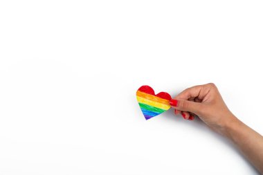 LGBT gurur bayrağıyla yapılmış, kalbi LGBTQ gurur rengine boyanmış. Onur Günü kavramı, Sevgililer Günü, özgürlük, aşk. Kalbi tutan el. Düz konum, üst görünüm, şablon, genel giderler.