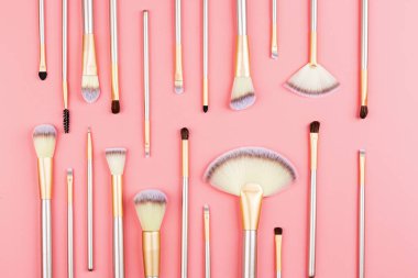 Pembe arka planda kozmetik makyaj fırçaları. Düz konum, üst görünüm, kopyalama alanı. Makyaj aksesuarları, model, şablon.