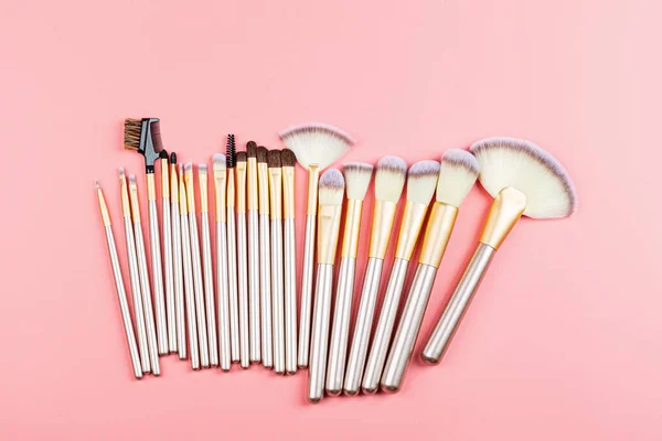 Cosmetic Makeup brushes on pink background. Flat lay, top view, copy space. Makeup accessories, mockup, template.