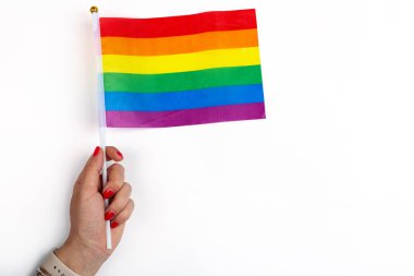 LGBT gurur bayrağıyla yapılmış, kalbi LGBTQ gurur rengine boyanmış. Onur Günü kavramı, Sevgililer Günü, özgürlük, aşk. Kalbi tutan el. Düz konum, üst görünüm, şablon, genel giderler