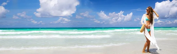 Красивая сексуальная молодая женщина в синем бикини и соломенной шляпе на песчаном пляже. Летний отдых, путешествия и туризм после прекращения работы коронавируса covid-19. Горизонтальный веб-баннер — стоковое фото
