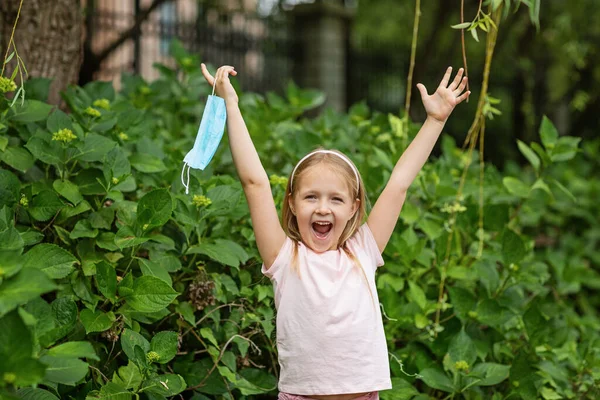 Happy Little Girl Takes Protective Medical Mask Face Outdoors Victory — Stock Photo, Image