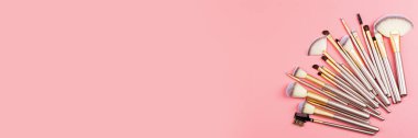 Pembe arka planda kozmetik makyaj fırçaları. Düz konum, üst görünüm, kopyalama alanı. Makyaj aksesuarları, model, şablon.