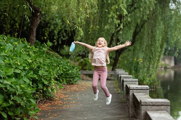 Happy Little Girl Takes Protective Medical Mask Face Outdoors Victory — Stock Photo, Image