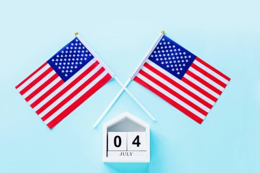 4 Temmuz. 4 Temmuz ahşap takvim ve mavi arka planda ABD bayrağı. Uzayı metin için kopyala. Amerika 'nın Bağımsızlık Günü. Düz konum, üst görünüm, şablon.