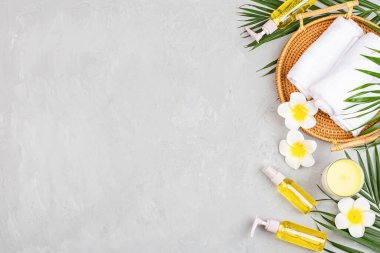 Spa masajı, vücut bakımı geçmişi. Gri taş masadaki kaplıca topları, kozmetik ürünleri, havlu ve palmiye yaprakları. Üst manzara, düz yatış, genel giderler, kopyalama alanı. Güzellik ve sağlık hizmetleri kavramı