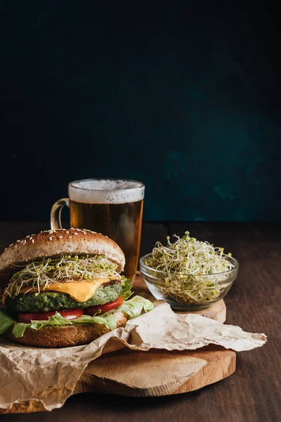 Wegańskie hamburgery i geer szkło na szczycie drewnianej deski, z miską kiełkujących nasion — Zdjęcie stockowe
