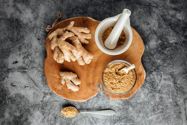 Natural ginger and ground with a mortar on a stone table. Natural medicine — Stock Photo, Image