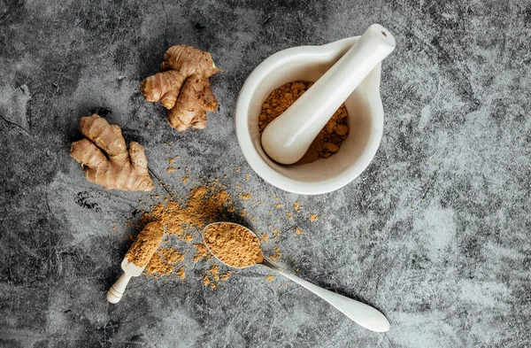 Natural ginger and ground with a mortar on a stone table. Natural medicine — Stock Photo, Image