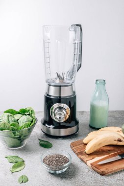 Masada ıspanaklı içecek yapmak için blender ve malzemelerle dolu bir hayat. Boş karıştırıcı