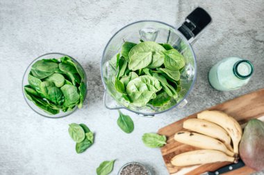 Masada ıspanaklı içecek yapmak için blender ve malzemelerle dolu bir hayat. Üst görünüm