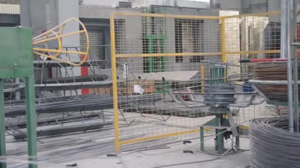 Rebar spool rotates on support supplying welding machine — Stockvideo