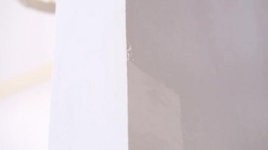 skilled handyman colours white wall edge in brown closeup