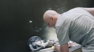 Adam elektrikli süpürgeyle daireyi tamir ediyor.