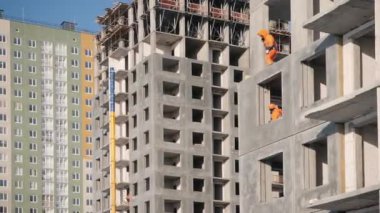 Parlak elbiseli çalışanlar kattaki montaj işlerini yürütürler.
