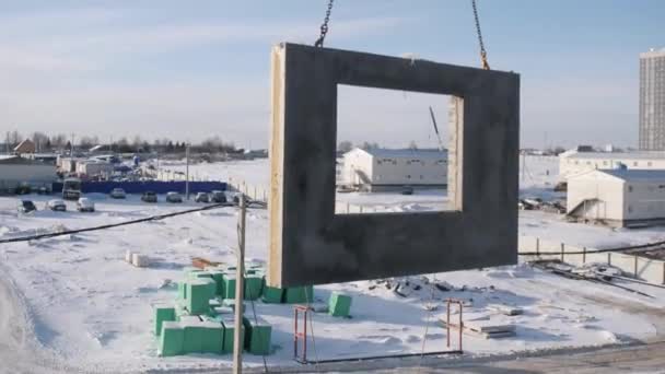 Żuraw wieżowy przewozi betonową płytę nad placem budowy — Wideo stockowe