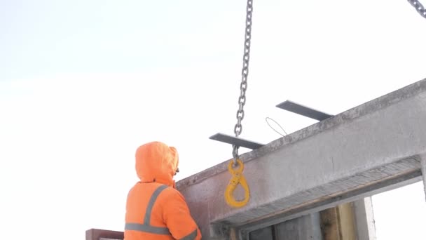 Bouwer gaat naar boven ladder aan haak betonnen paneel aan ophanging — Stockvideo