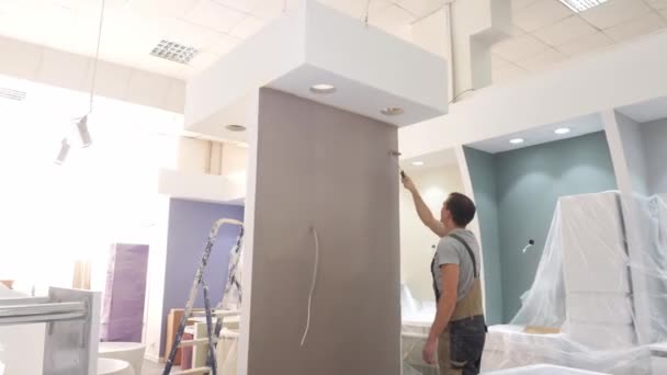 Person i overall färger ny lägenhet vägg i brunt — Stockvideo