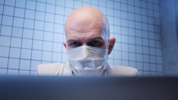 Plešatý muž pracuje na počítači v koronavirové výzkumné laboratoři — Stock video
