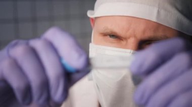 Ciddi bir doktor laboratuarda etiket Coronavirus ile test tüpü tutuyor.