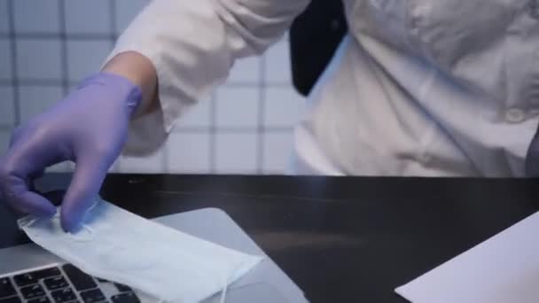 Muž nasadí ochrannou masku v laboratoři na výzkum koronaviru — Stock video