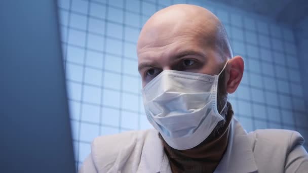 Plešatý lékař pracuje na počítači v koronavirové výzkumné laboratoři — Stock video