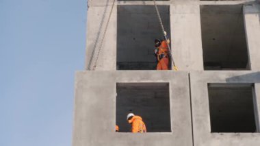 İşçiler seçkin ev inşaatında çalışıyor. Düşük açılı çekim.