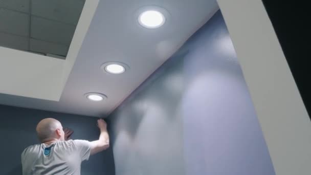Pintor dibuja líneas rectas pintando paredes en color lila — Vídeos de Stock