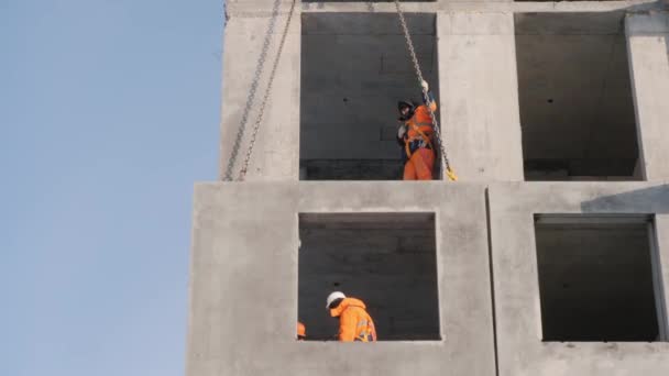 Trabajadores trabajan en la construcción de casas de élite tiro de ángulo bajo — Vídeo de stock