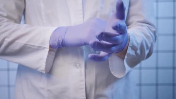 Doctor puts on gloves in coronavirus researching lab — Stockvideo