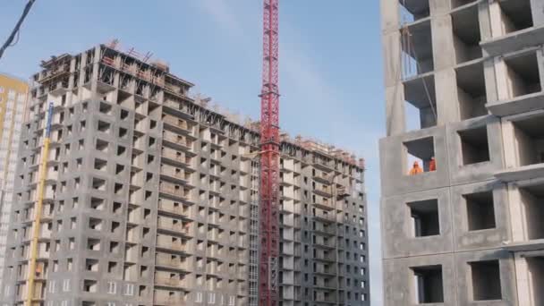 Lattice crane tower between houses built of panel blocks — Stock video