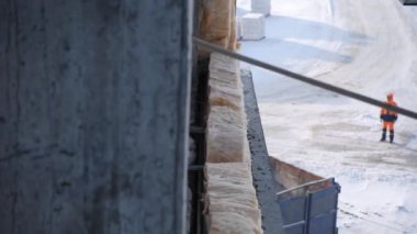 wall panel lifted by crane approaches monolithic building