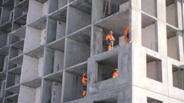builders finish mounting lifted concrete panel in house
