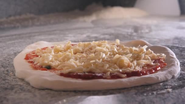 Cocinar vierte aceite en masa de pizza cruda con salsa de tomate y queso — Vídeo de stock