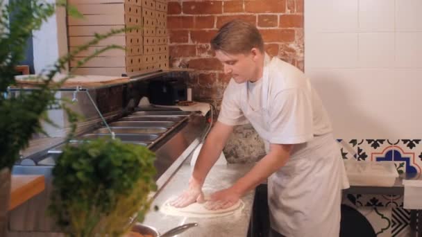 Pizza maker vormt dun deeg staan achter cafe teller — Stockvideo