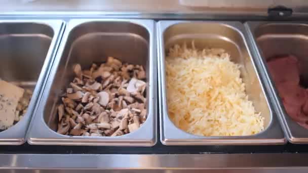 Restaurant chef takes grated cheese from counter container — Stock Video