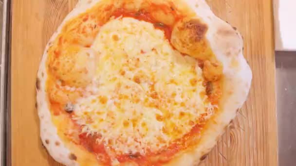 Pizzeria chef sprinkles cooked baked pizza with black pepper — Stock Video
